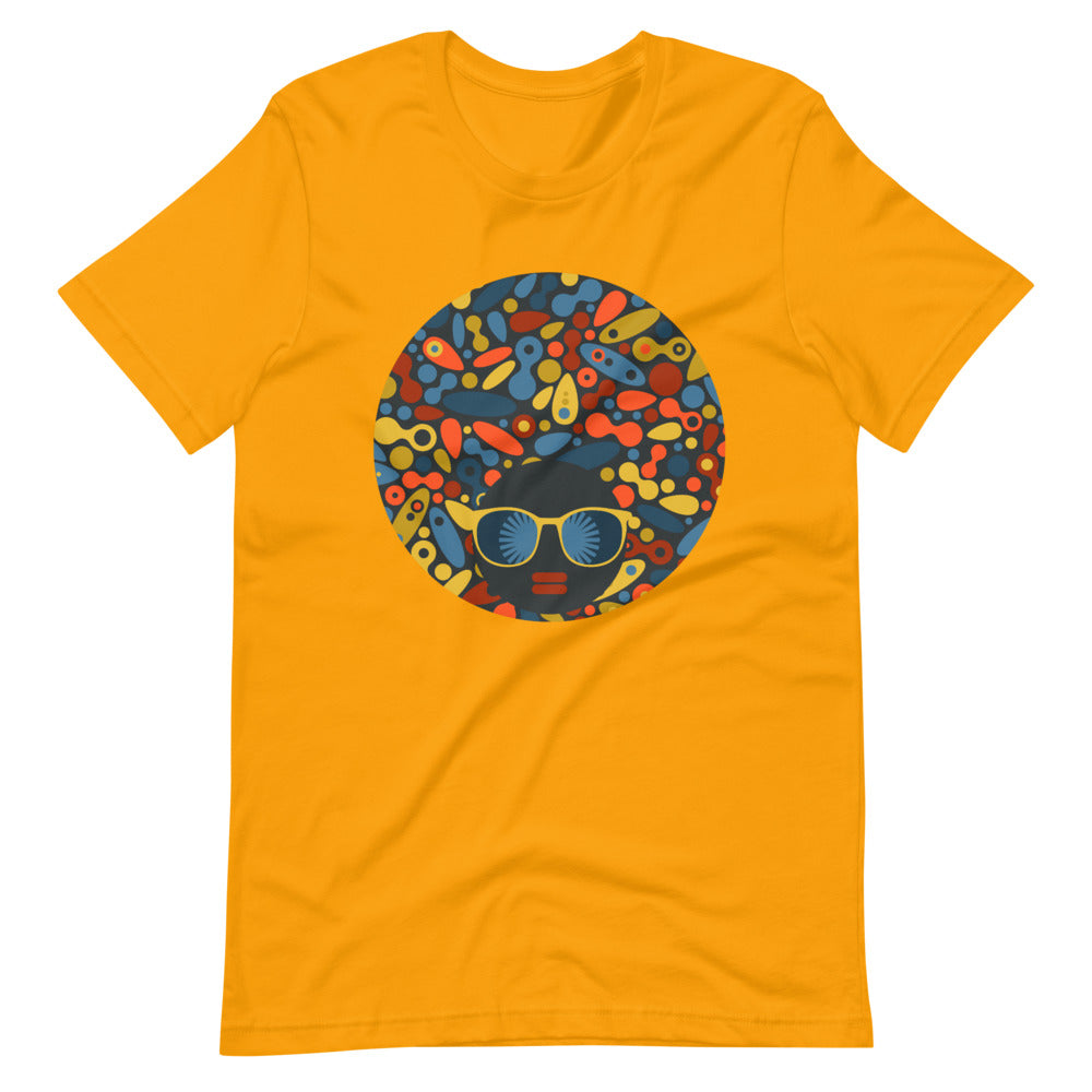 Gold color t shirt with colorful design of a black women with geometric shapes and cool glasses "Be Bold"